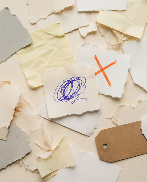Recortes de papel espalhados e desconectados, representando ideias soltas